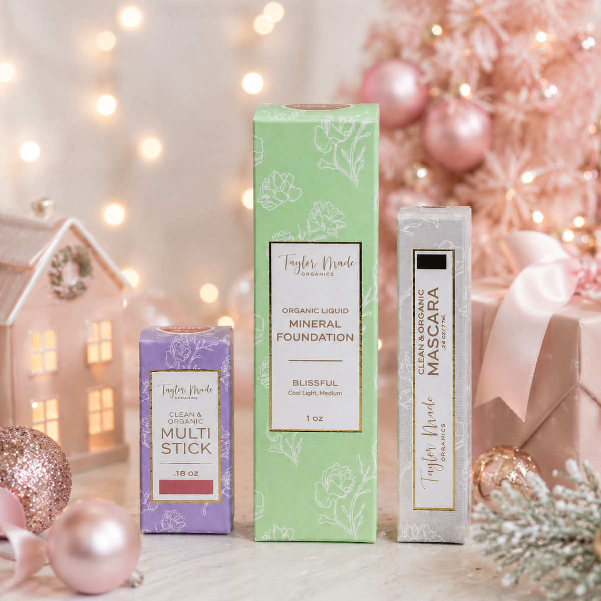 Taylor Made Organics Clean Beauty Bundle with Multistick, Blissful Liquid Mineral Foundation, and Mascara in a pink Christmas setting.