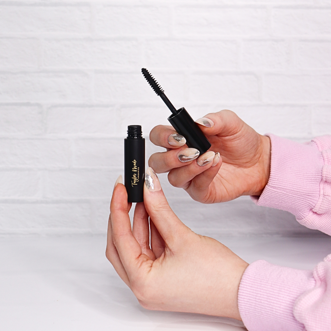 Taylor Made Organics Black Mascara in models hand – organic, non-toxic makeup made in the USA