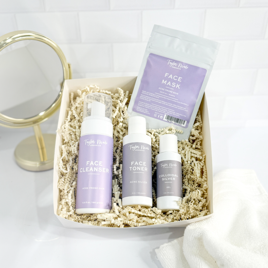 Set of facial skincare products including cleanser, toner, and mask in a box with a mirror on a white background.