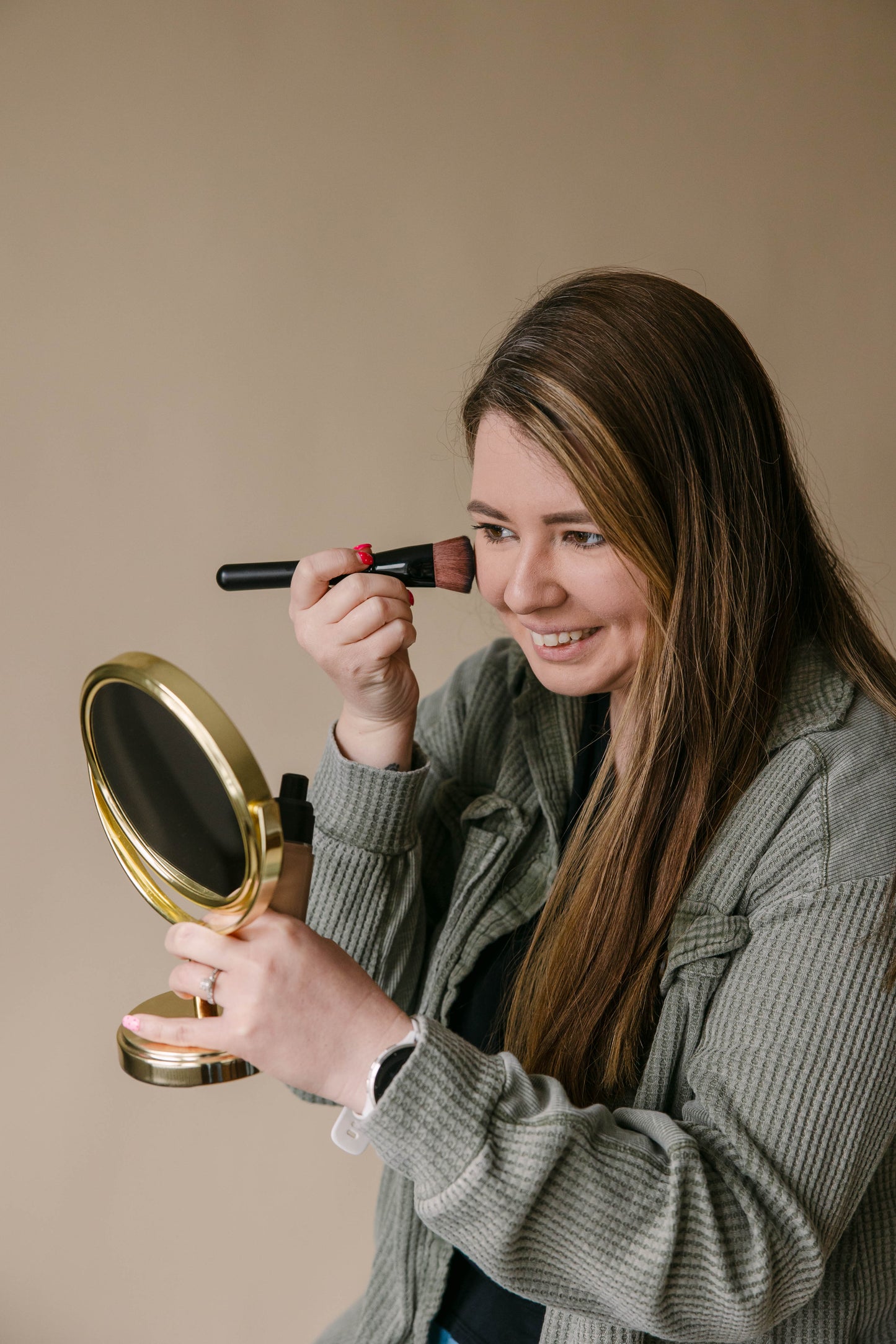 Woman applying liquid organic mineral foundation to face | Taylor Made Organics