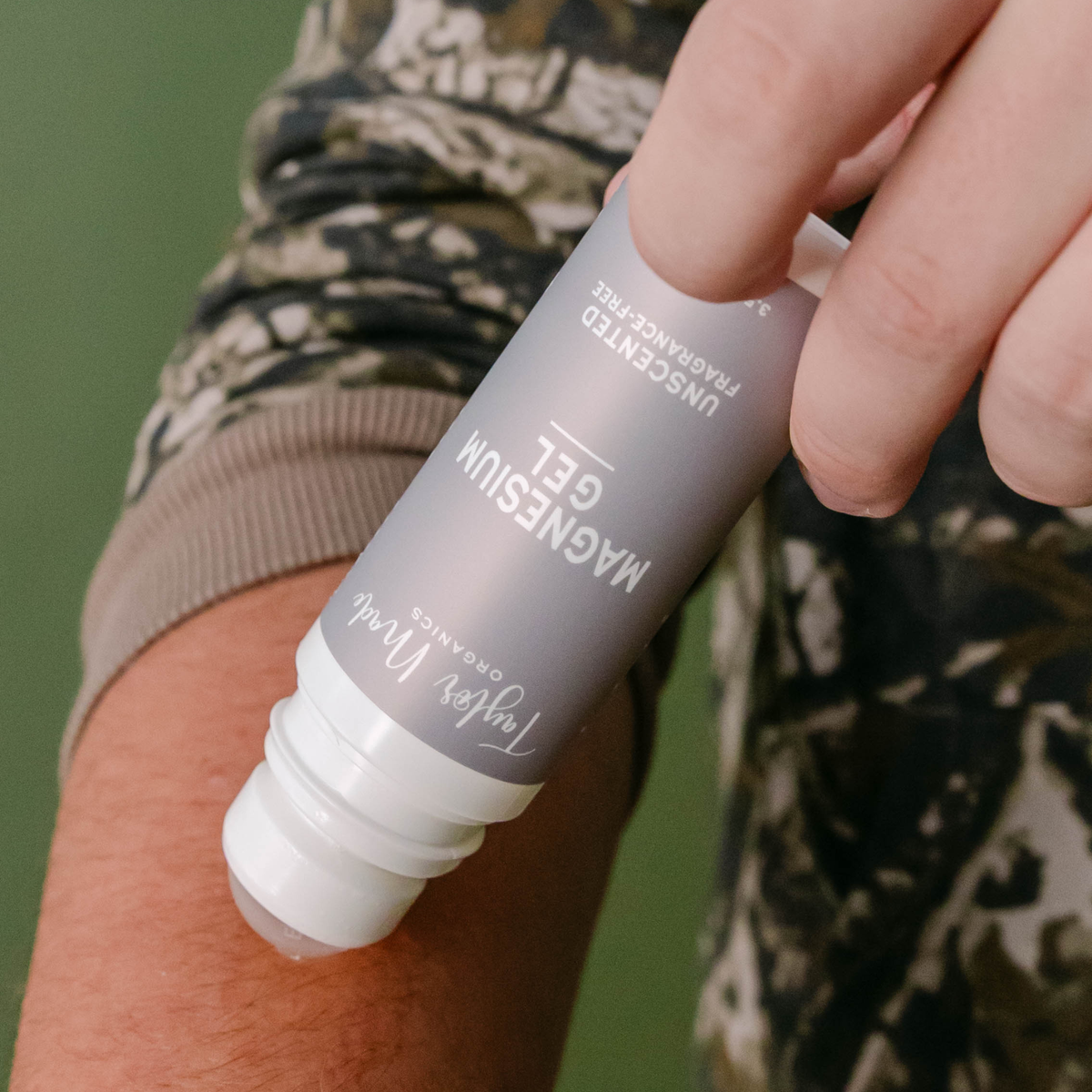 Person applying Taylor Made Organics Unscented Magnesium Gel to their forearm with the roll-on applicator.
