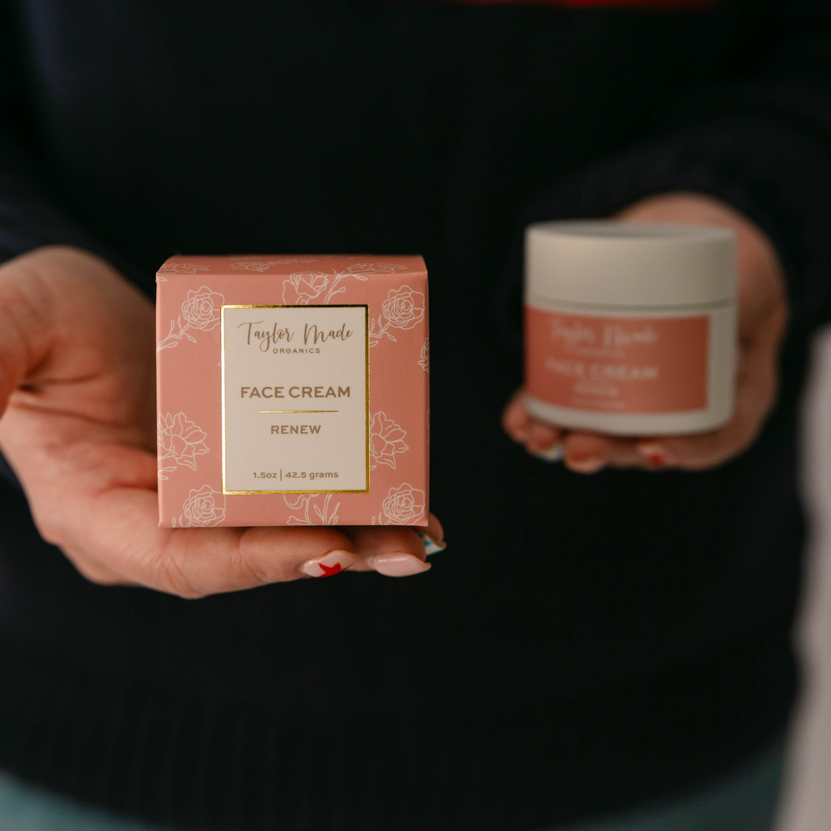 Woman holding Taylor Made Organics Renew Face Cream jar and pink floral product box.